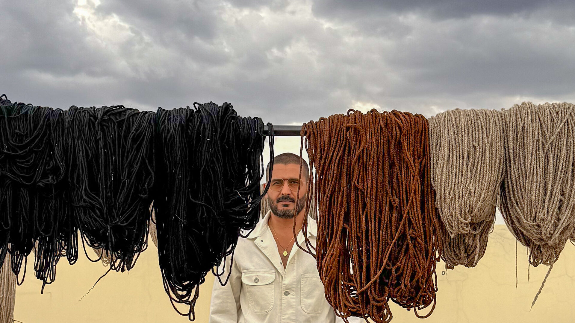 NICH among the drying wool skeins under a stormy sky