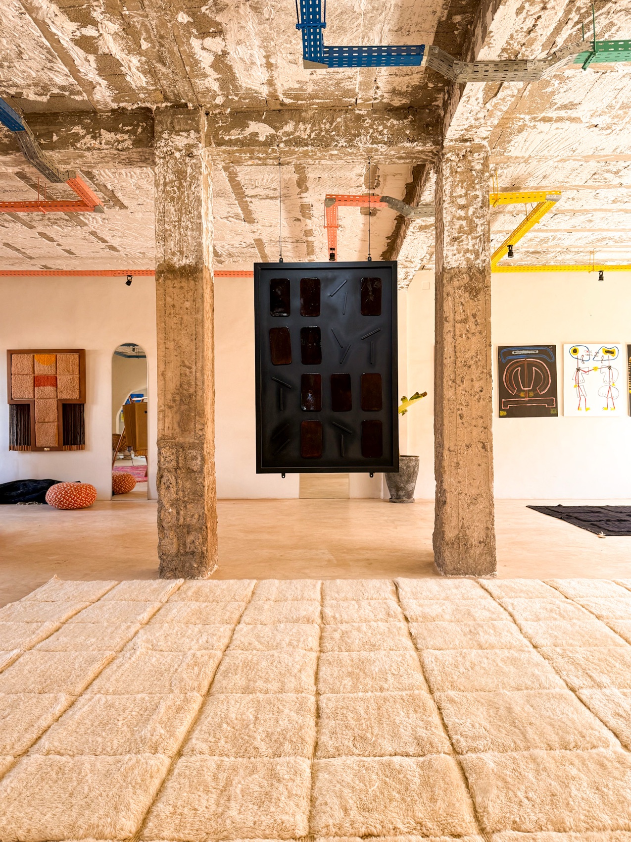 Concrete pillars and a tiled tufted floor piece