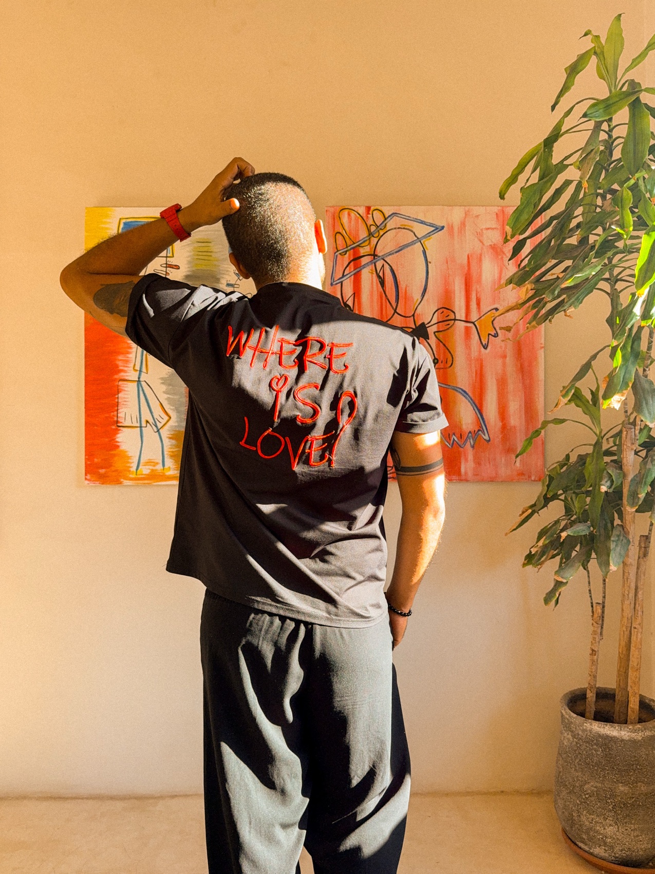 NICH in front of his paintings in the studio