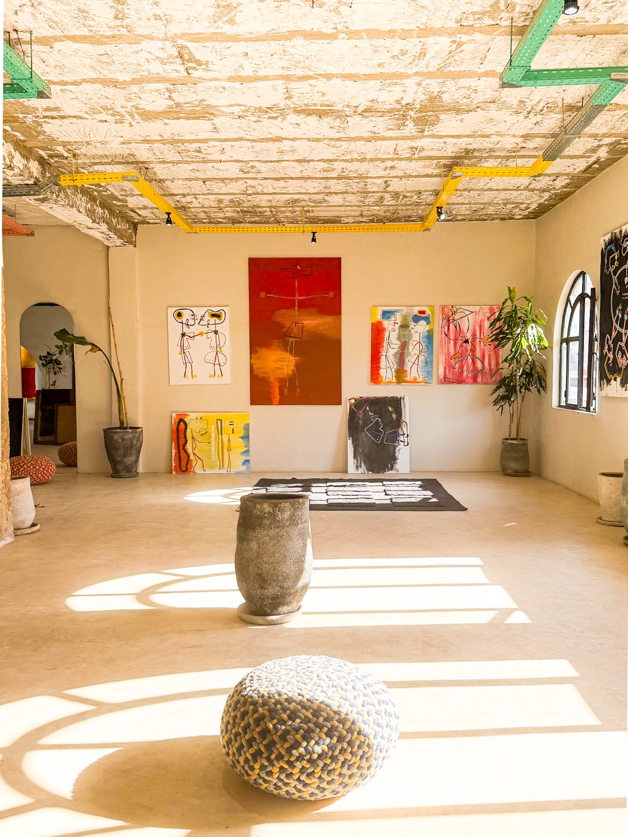 Studio interior with paintings and tufted rug