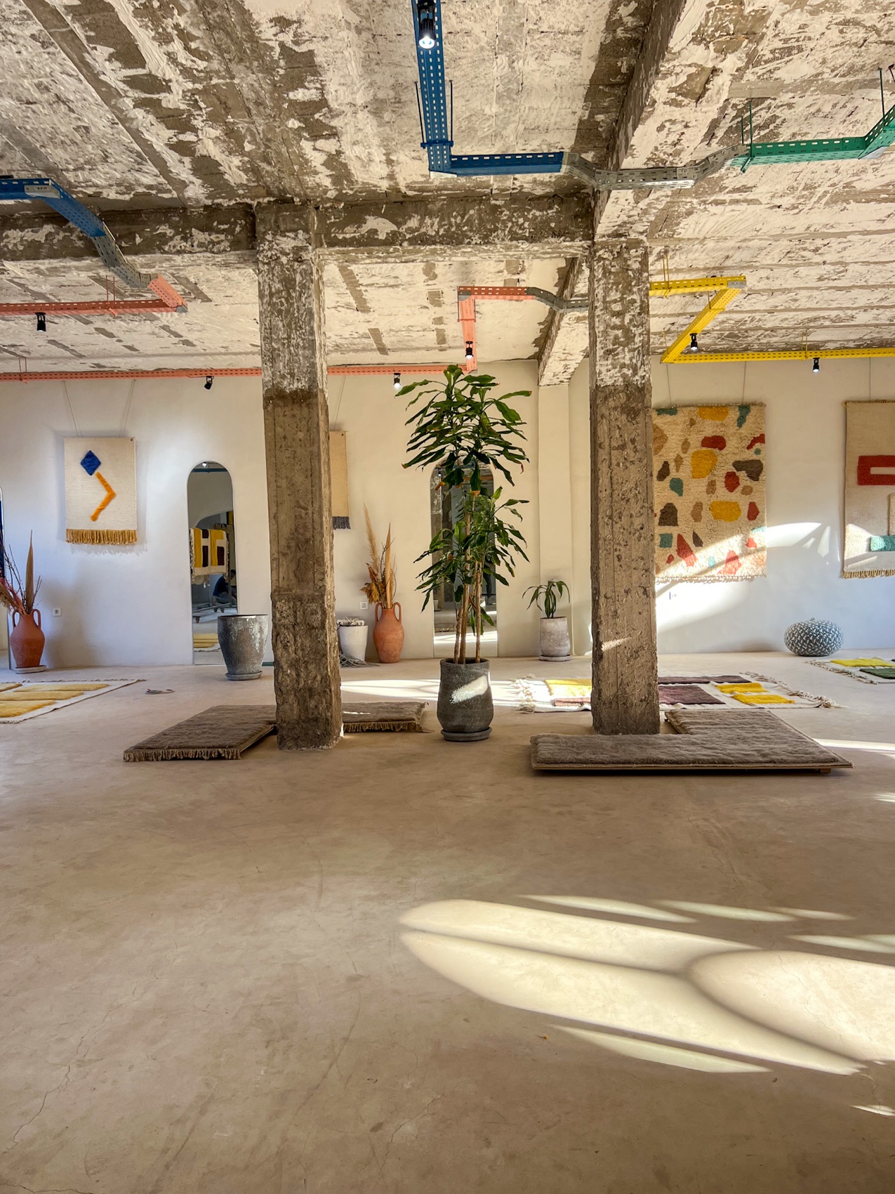 The NICH atelier — concrete pillars, painted beams and tufted works